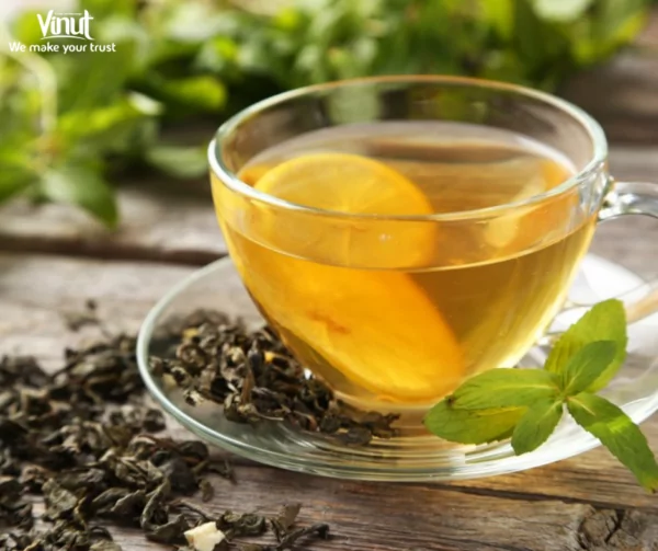 VINUT_a cup with green tea leaves with a slice of lemon